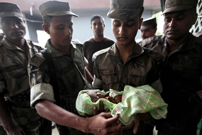 Các chiến sĩ biên phòng Bangladesh bế một bé gái bị bỏ rơi trên một chiếc thuyền ở Taknaf, Bangladesh ngày 22/6. Các chiến sĩ biên phòng Bangladesh bế một bé gái bị bỏ rơi trên một chiếc thuyền ở Taknaf, Bangladesh ngày 22/6.