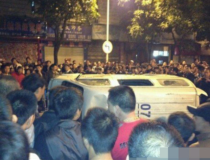 Đám đông người biểu tình lật ngược xe của cảnh sát vì cho rằng cuộc truy đuổi lái xe vi phạm giao thông là nguyên nhân dẫn tới tai nạn.