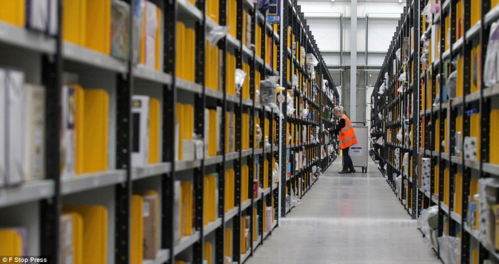 Một nhân viên của Amazon giữa những kệ hàng khổng lồ. Một nhân viên của Amazon giữa những kệ hàng khổng lồ.