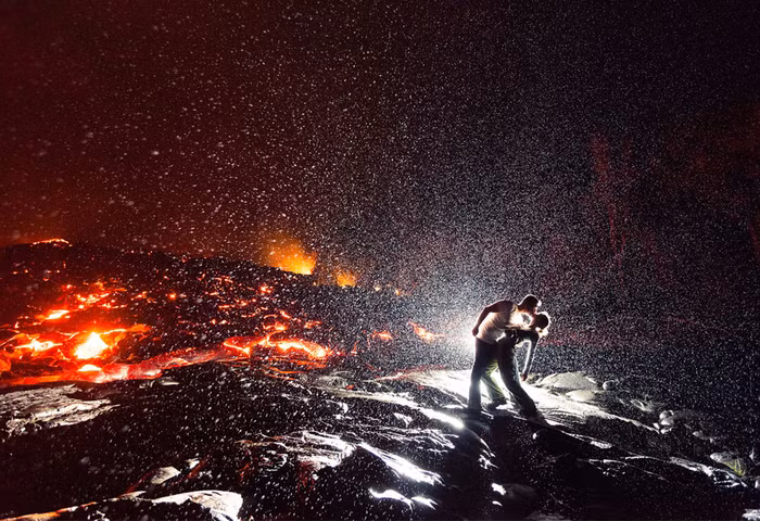 Vợ chồng nhiếp ảnh gia Dallas Nagata White trao nụ hôn cạnh miệng núi lửa ở Kalapana, Hawaii.