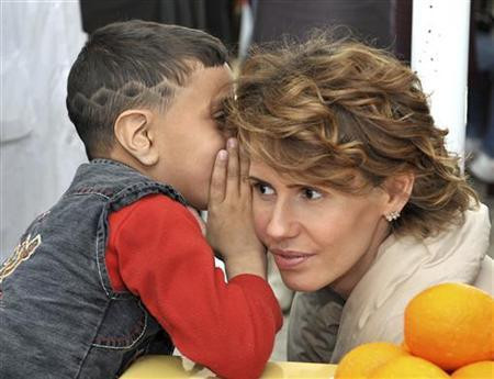 Một trong số các cậu con trai thì thầm với bà Asma.. Bà Asma từng được tờ Vogue gọi là '"Bông hồng sa mạc" trong cuộc phỏng vấn đầu năm 2011.