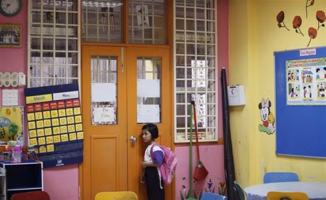 Nuranisya Alihasdi, 6 tuổi, từ chối hòa nhập với các bạn và lẻn sang phòng khác đứng một mình trong ngày đầu tiên tới trường ở Putrajaya, ngoại ô Kuala Lumpur, Malaysia ngày 4/1