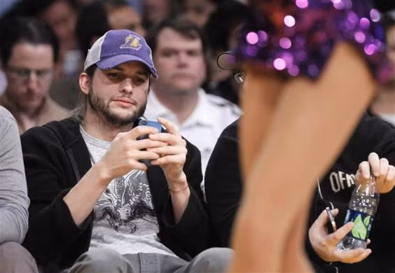 Diễn viên Ashton Kutcher đã xem điện thoại di động riêng trong suốt quá trình biễn ra trân NBA giữa đội Los Angeles Lakers và Houston Rockets tại Los Angeles, California ngày 3/1