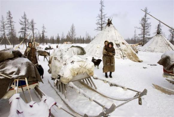 Phụ nữ Nenets đứng cạnh những chiếc xe chất đầy đồ đạc trên bán đảo Yamal Phụ nữ Nenets đứng cạnh những chiếc xe chất đầy đồ đạc trên bán đảo Yamal