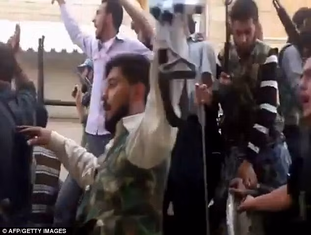 Phiến quân Syria diễu hành trên phố theo một chiếc xe tăng nhóm này tuyên bố tịch thu từ lực lượng an ninh chính phủ.