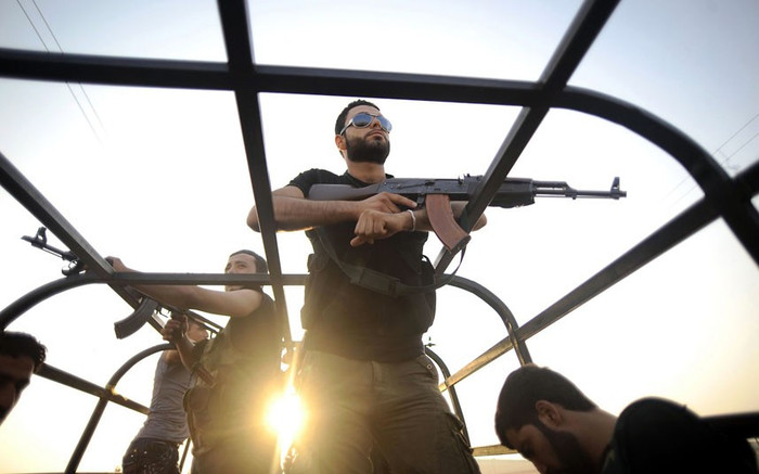 Phiến quân Syria tuần tra trên đường phố gần Aleppo.