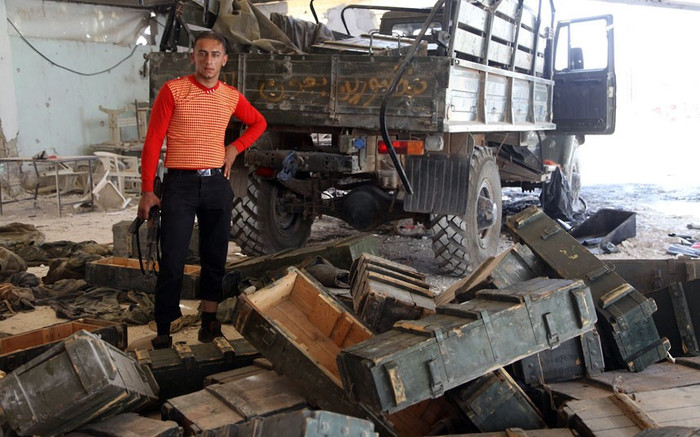 Một tay súng nổi dậy đứng giữa những thùng đạn bị bỏ lại bởi quân chính phủ sau khi chiếm một trạm kiểm soát tại làng Anadan, cách tây bắc Aleppo khoảng 5km.