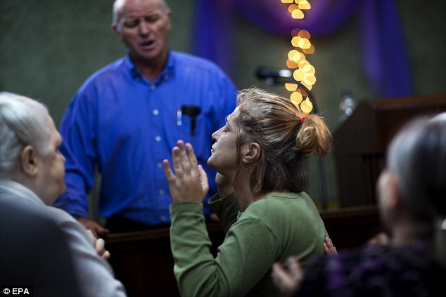 Các tín đồ cầu nguyện sau khi được xức dầu