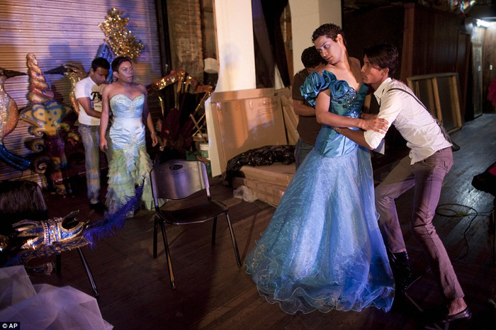 Laveleska Dredrish được một trong hai phụ tá giúp đỡ mặc bộ váy lộng lẫy màu xanh