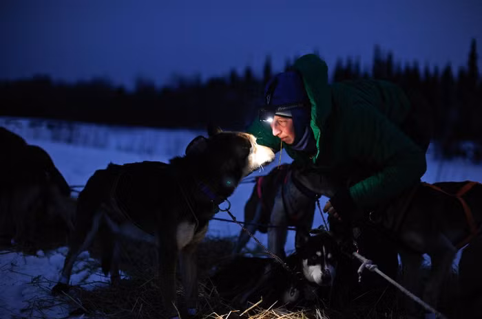 Musher Colleen Robertia nhìn Quigley khi cô chuẩn bị rời trạm kiểm soát tại Nikolai, Alaska ngày 6/3.