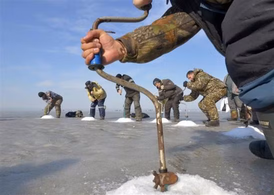 Ngư dân khoan lỗ băng câu cá tại thành phố viễn đông Vladivostok của Nga ngày 19/2/2012.