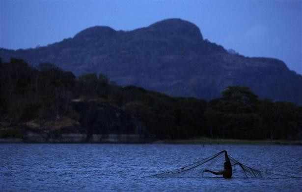 Một ngư dân đang chuẩn bị lưới đánh cá đêm tại hồ Kandalama, gần Dambulla, Sri Lanka ngày 31/7/2009.
