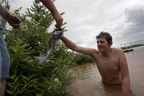 Colby Deck đưa con cá tra bắt bằng tay cho người bạn ở Oklahoma ngày 30/6/2007.