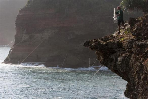 Một ngư dân đang sửa lưới bắt tôm hùm tại bãi biển Timang ở Gunung Kidul, gần thành phố cổ Yogyakarta, Indonesia ngày 19/4/2012.