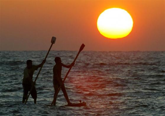 Ngư dân Palestine chèo thuyền lúc mặt trời lặn ở dải Gaza ngày 17/9/2004.