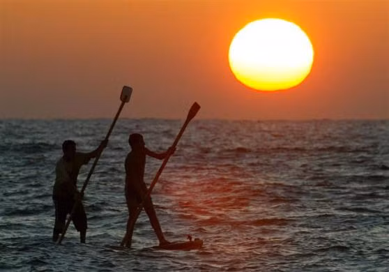 Ngư dân Palestine chèo thuyền lúc mặt trời lặn ở dải Gaza ngày 17/9/2004.