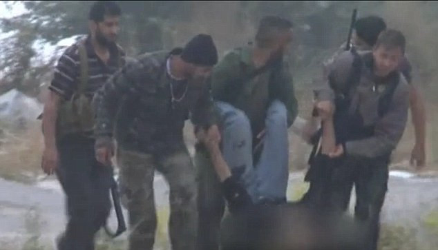 Thi thể một tay súng nổi dậy được đồng đội mang đi.