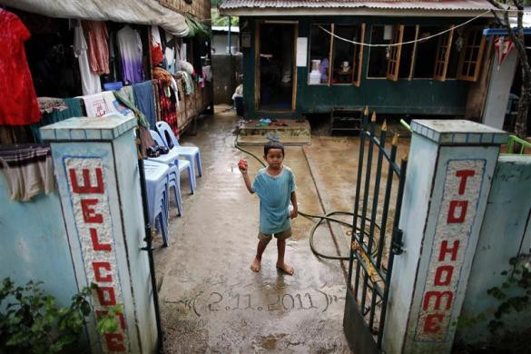 Một em bé nhiễm HIV đứng ở lối vào nhà tế bần ở ngoại ô thành phố Yangon, Myanmar ngày 26/5/2012.