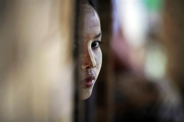 Zinmar Nwe, 27 tuổi, nhìn ra ngoài từ bên trong túp lều của mình tại nhà tế bần ở ngoại ô thành phố Yangon, Myanmar ngày 26/5/2012.