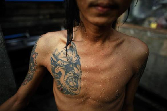 Một bệnh nhân HIV để lộ hình xăm quỷ trên ngực tại nhà tắm ở nhà tế bần ở ngoại ô thành phố Yangon, Myanmar ngày 26/5/2012.