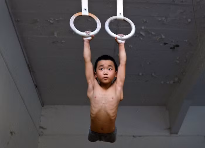 Một cậu bé thuộc đội thể dục dụng cụ tập luyện tại trường thể thao ở Nam Kinh, tỉnh Giang Tô, Trung Quốc.