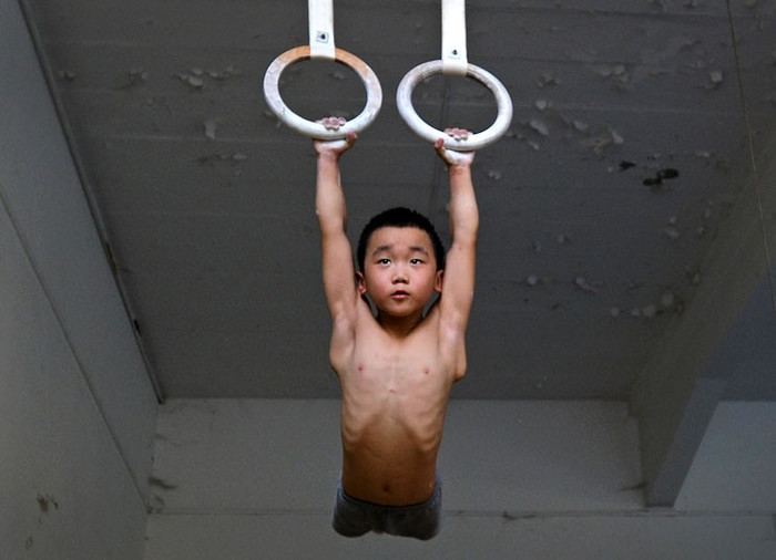 Một cậu bé thuộc đội thể dục dụng cụ tập luyện tại trường thể thao ở Nam Kinh, tỉnh Giang Tô, Trung Quốc. Một cậu bé thuộc đội thể dục dụng cụ tập luyện tại trường thể thao ở Nam Kinh, tỉnh Giang Tô, Trung Quốc.