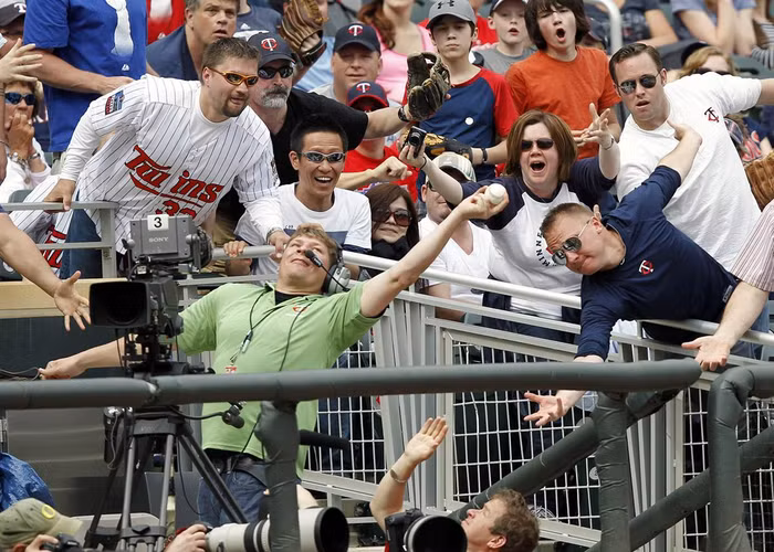 Một người quay phim bắt được quả bóng phạm lỗi trong hiệp 9 của một trận đấu tại giải bóng chày Twins' American League ở Minneapolis (Mỹ) ngày 14/4.