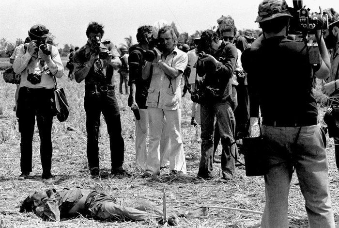 Các phóng viên chụp ảnh thi thể một người đàn ông gần Sài Gòn đầu năm 1968.