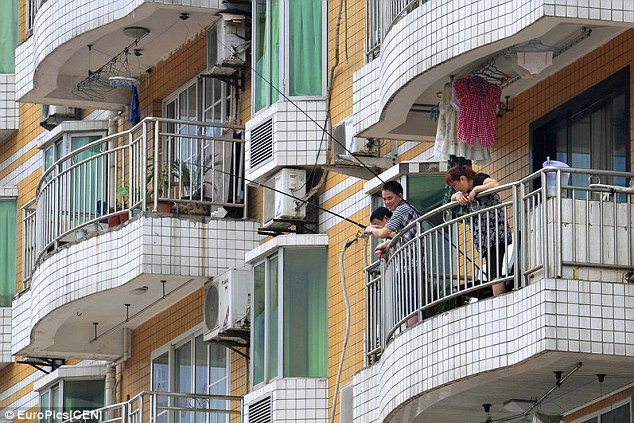 Người dân đổ xô đi câu cá từ ban-công tòa nhà chung cư với hy vọng kiếm được thực phẩm tươi cho bữa tối khi bị kẹt trong lũ lụt.