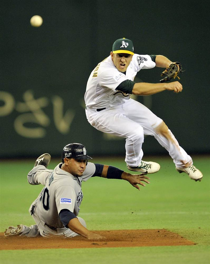 Cầu thủ Cliff Pennington của đội Oakland Athletics ném bóng khi Miguel Olivo của đội Seattle Mariners bắt trượt trong hiệp 2 của trận đấu mở màn mùa giải bóng chày Major League tại sân Tokyo Dome ở Tokyo, Nhật Bản ngày 28/3. Cầu thủ Cliff Pennington của đội Oakland Athletics ném bóng khi Miguel Olivo của đội Seattle Mariners bắt trượt trong hiệp 2 của trận đấu mở màn mùa giải bóng chày Major League tại sân Tokyo Dome ở Tokyo, Nhật Bản ngày 28/3.