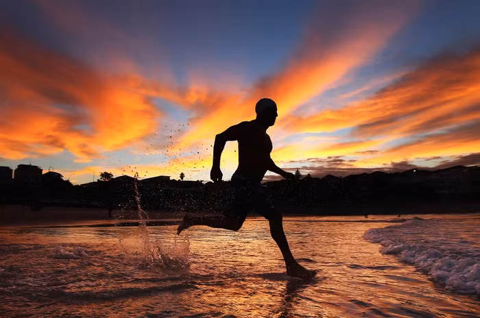Vận động viên bơi lội chạy trên bãi biển Bondi, Sydney, Úc ngày 27/3. Vận động viên bơi lội chạy trên bãi biển Bondi, Sydney, Úc ngày 27/3.