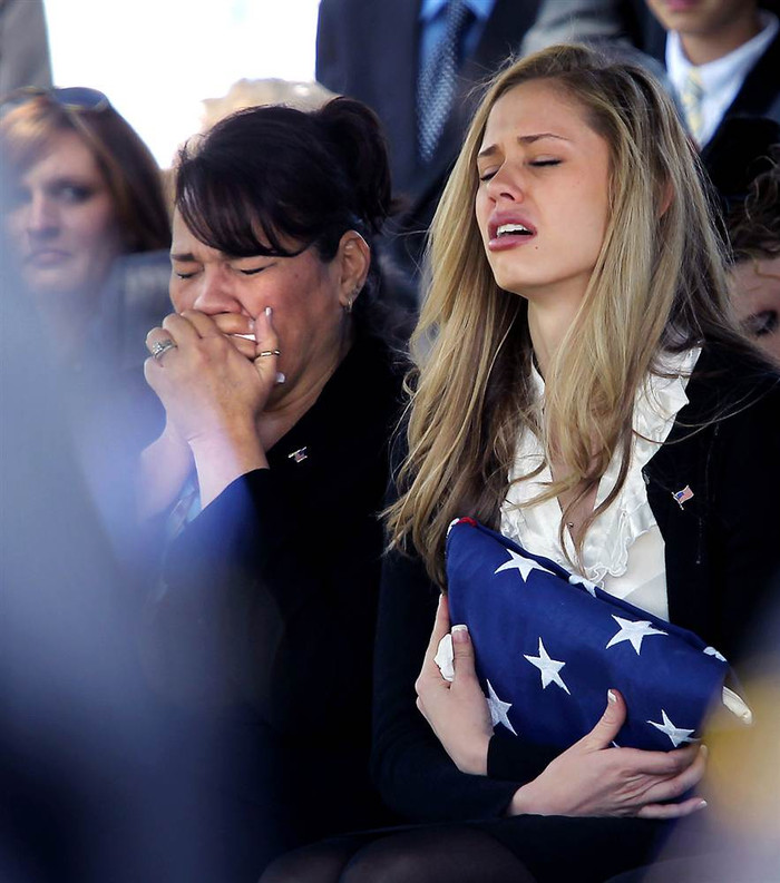 Ashley Van Zandt (phải) - hôn thê của Trevor Daniel Jones, nhân viên cảnh sát Bakersfield, ôm quốc kỳ Mỹ trong tang lễ của Jones ngày 27/3 tại nghĩa trang Hillcrest Memorial ở Bakersfield, California (Mỹ). Jones (23 tuổi) qua đời vì đau tim do máu đông chỉ vài ngày trước lễ cưới. Ashley Van Zandt (phải) - hôn thê của Trevor Daniel Jones, nhân viên cảnh sát Bakersfield, ôm quốc kỳ Mỹ trong tang lễ của Jones ngày 27/3 tại nghĩa trang Hillcrest Memorial ở Bakersfield, California (Mỹ). Jones (23 tuổi) qua đời vì đau tim do máu đông chỉ vài ngày trước lễ cưới.