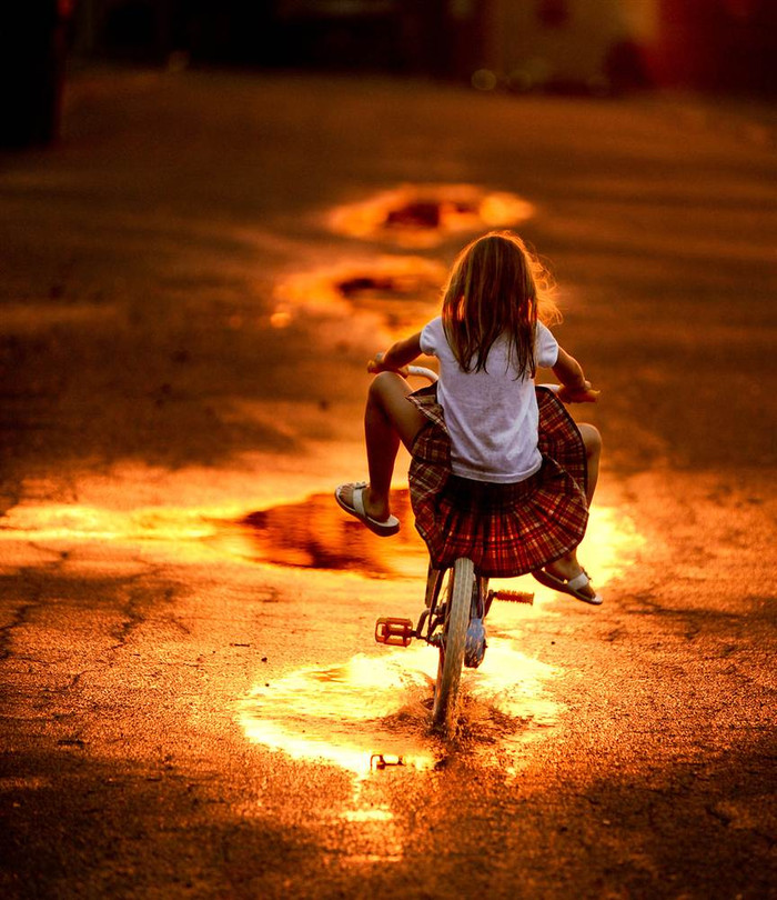 Opal Cosby kiễng chân khi đạp xe qua vũng nước ở Ironwood, Hartselle, Alaska (Mỹ) trong chiều mưa ngày 22/3. Opal Cosby kiễng chân khi đạp xe qua vũng nước ở Ironwood, Hartselle, Alaska (Mỹ) trong chiều mưa ngày 22/3.