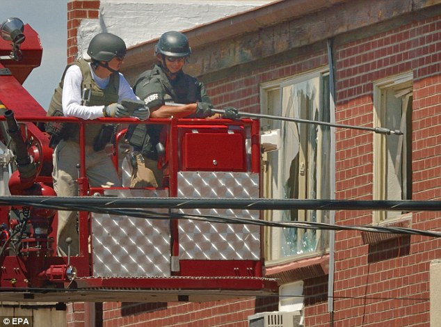 Các nhân viên an ninh tháo gỡ bẫy bom tinh vi trong căn hộ của James Holmes. Các nhân viên an ninh tháo gỡ bẫy bom tinh vi trong căn hộ của James Holmes.