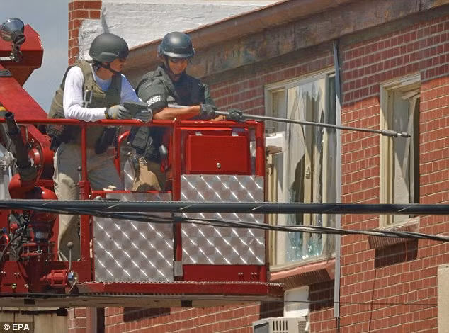 Các nhân viên an ninh tháo gỡ bẫy bom tinh vi trong căn hộ của James Holmes.