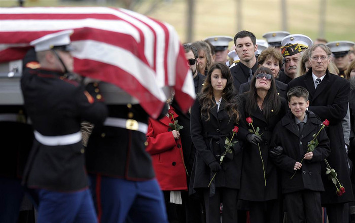 Catherine Stouffer cùng hai người con Shannon (17 tuổi) và Shane (12 tuổi) đi bên cạnh linh cữu của chồng - một cựu sĩ quan Hải quân - trên đường tới nghĩa trang tại Arlington Cemetery ở Arlington (Mỹ) ngày 7/12. Anh Gary Stouffer (37 tuổi) bị giết hại trong một cuộc diễu hành tại Midland, Texas, vào ngày 15/11.