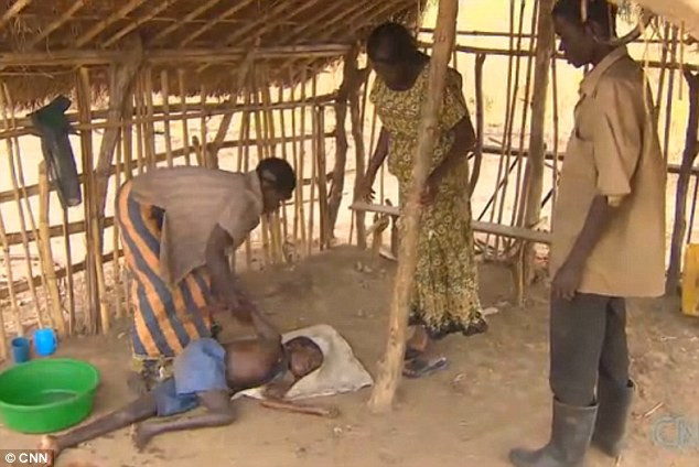 Một em bé mắc bệnh gật đầu ngủ gục trên nền đất Một em bé mắc bệnh gật đầu ngủ gục trên nền đất