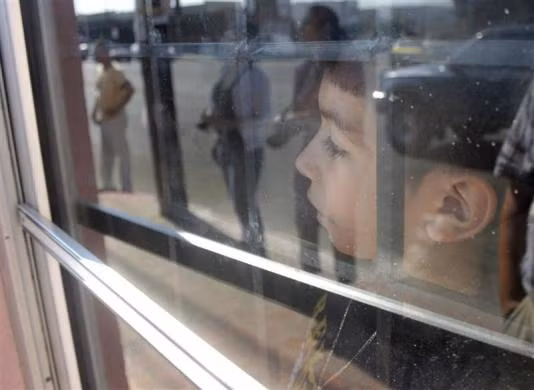 Saul, 8 tuổi, nhìn qua cửa sổ tàu chờ mẹ khi cả hai bị trục xuất khỏi nước Mỹ ngày 20/8/2007.