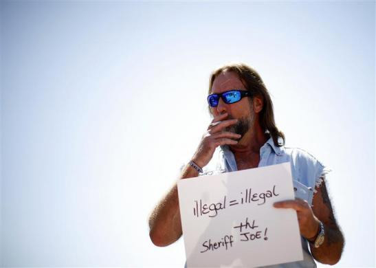 Mark Renner hút thuốc lá tại một cuộc biểu tình phản đối việc cảnh sát Mỹ đàn áp người nhập cư tại Fountain Hills, Arizona ngày 28 tháng 4 năm 2012. Mark Renner hút thuốc lá tại một cuộc biểu tình phản đối việc cảnh sát Mỹ đàn áp người nhập cư tại Fountain Hills, Arizona ngày 28 tháng 4 năm 2012.