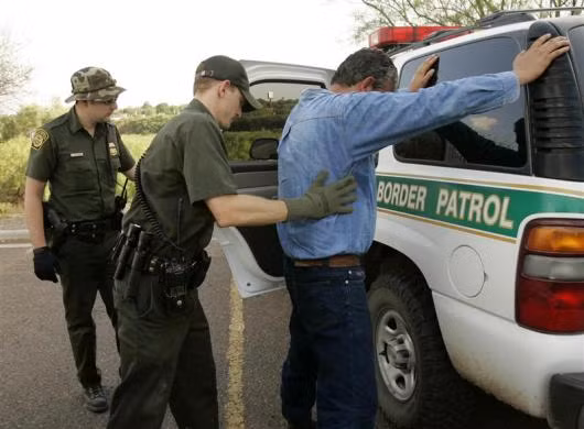 Các nhân viên kiểm soát biên giới của Mỹ kiểm tra một người nhập cư Mexico không có giấy tờ. Người đàn ông này bị bắt Laredo, Texas ngày 1/5/2006.
