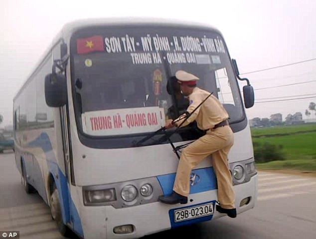 Trung úy Phan bám kính chắn gió để ngăn lái xe phạm luật. Trung úy Phan bám kính chắn gió để ngăn lái xe phạm luật.