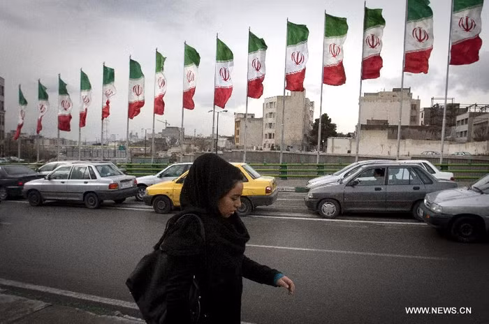 Một phụ nữ đi bộ qua con phố ngập quốc kỳ Iran tại phía bắc thủ đô Tehran ngày 2/2