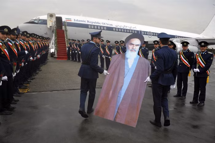 Các binh sĩ Không quân Iran mang bức chân dung người sáng lập nhà nước Cộng hòa Hồi giáo năm 1979 Ayatollah Ruhollah Khomeini lên máy bay tại sân bay Merhrabad, Tehran ngày 1/2.
