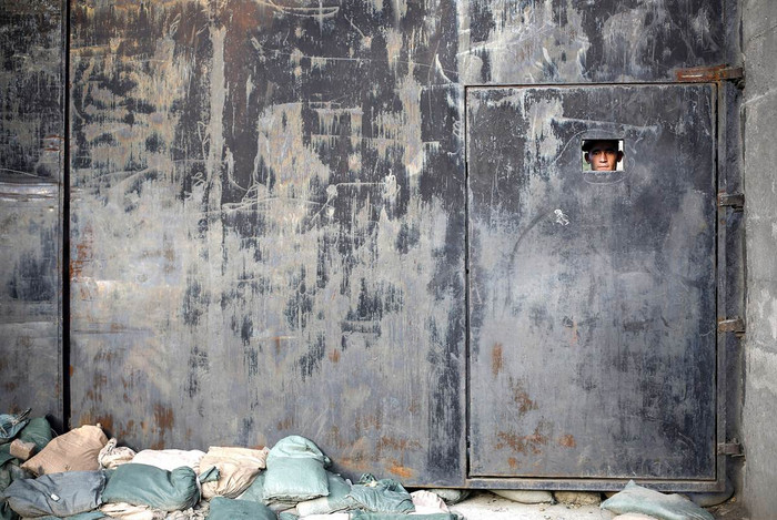 Một lính Afghanistan nhìn qua ô cửa nhỏ của căn cứ Nangalam tại thung lũng Pech, Afghanistan.