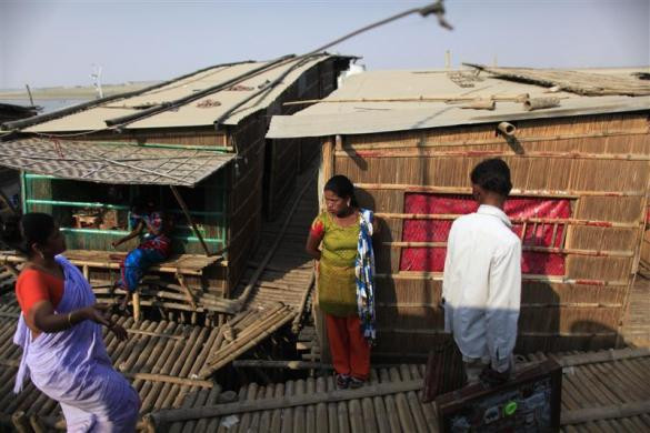 Gái mại dâm đứng trước một nhà thổ tạm bợ ven sông ở Faridpur, Bangladesh ngày 23/2/2012.