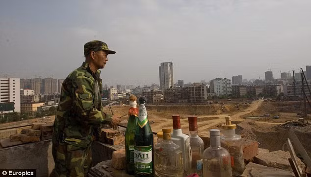 Ông Zou bên cạnh đám bom xăng để đối phó với các chủ đầu tư dự án.