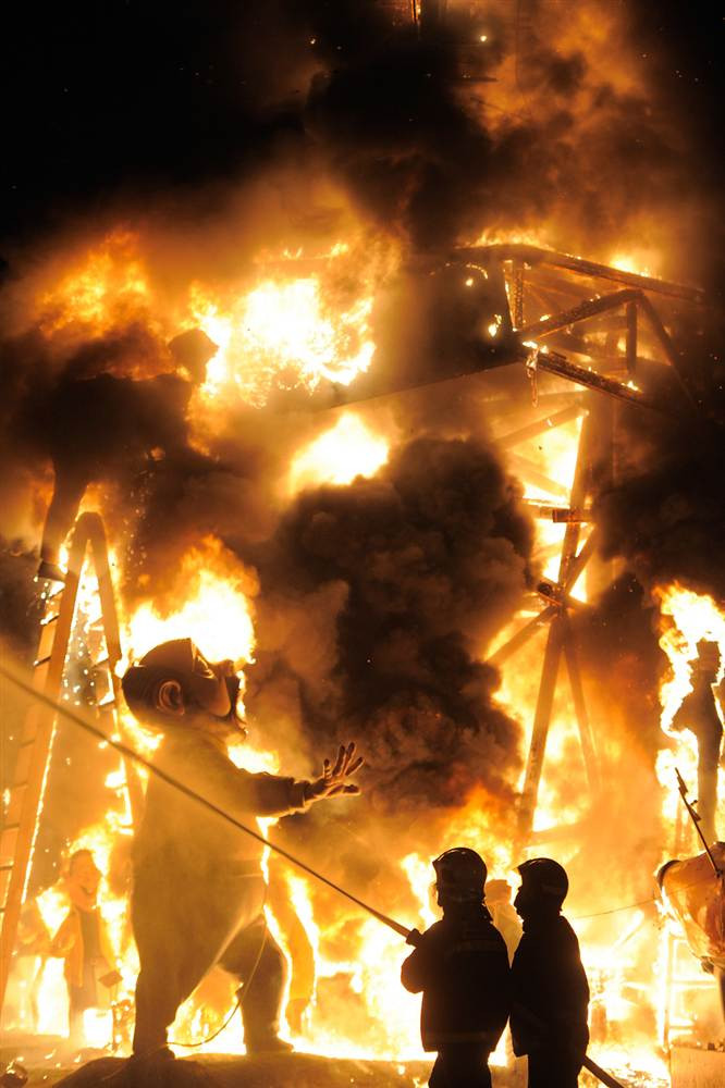 Nhân viên cứu hỏa đang phun nước lên một tác phẩm điêu khắc khi nó bị đốt cháy vào ngày cuối cùng của lễ hội Las Fallas ở Valencia, Tây Ban Nha ngày 19/3. Trong lễ hội kéo dài 10 ngày, người ta làm nhiều tác phẩm điêu khắc bằng gỗ, bìa cứng và trưng bày trên các con phố rồi đốt chúng vào ngày kết thúc lễ hội.