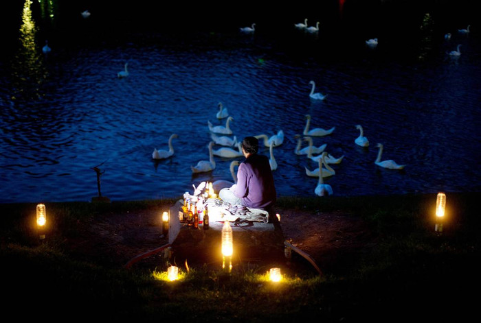 Một người đàn ông thắp nến ngắm những con thiên nga bơi trên kênh Landwehrkanal ở Berlin, Đức trong tối mùa hè ngày 1/8. Một người đàn ông thắp nến ngắm những con thiên nga bơi trên kênh Landwehrkanal ở Berlin, Đức trong tối mùa hè ngày 1/8.