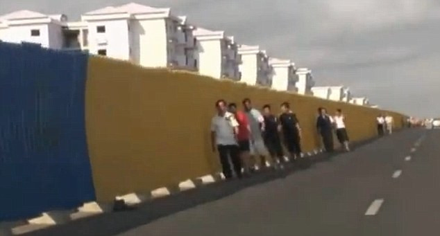 Lao động người Trung Quốc đi trên con đường gần khu đô thị Cidade de Kilamba