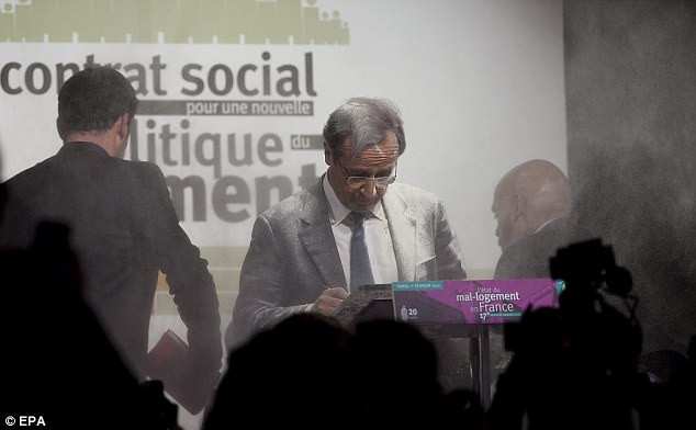 Ông Francois Hollande bình tĩnh tiếp tục bài phát biểu của mình trong lúc người phụ nữ biểu tình bị lực lượng an ninh bắt giữ